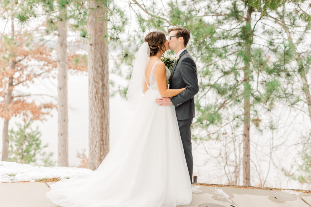 Bride and groom kissing at winter wedding